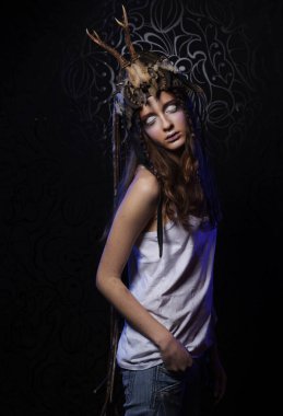 Parlak makyajlı, örgülü ve kafasında siyah arka planı olan genç bir kadın model.