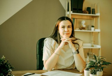 Uzaktan çalışan ya da internetten eğitim alan bir kadın tablet bilgisayar, kağıt ve notlar kullanıyor, gündüz evde ya da ofiste. Yeni meslek öğrenme kursları ya da yeni beceriler edinme üzerine uzaktan eğitim