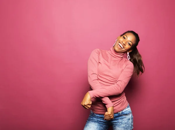 美しい若いアフロの女性の写真は 空のスペース孤立ピンク色の背景を見て踊るカジュアルな服を着ている 党と人民の概念 — ストック写真
