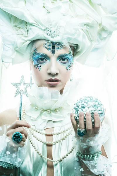 Parti, noel ve halk konsepti: mavi sanatsal makyajlı genç kadın. Kış Portresi. Kar Kraliçesi.