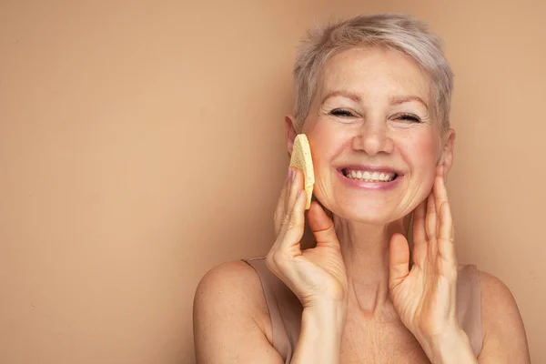 Mujer Anciana Sonriente Sosteniendo Esponja Limpiando Piel Cara Con Limpiador — Foto de Stock