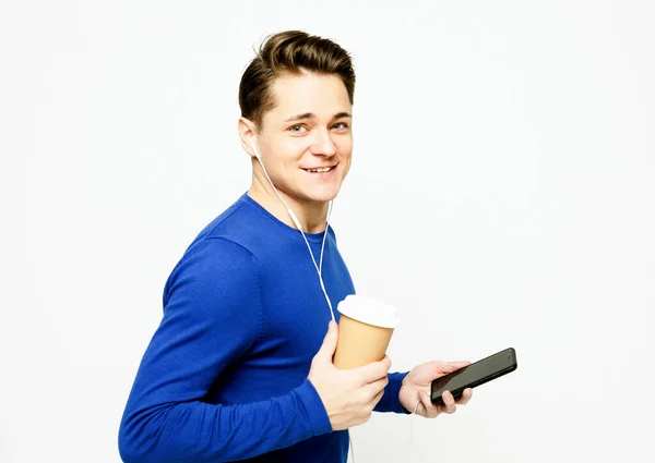 Mavi Kazaklı Gülümseyen Genç Adam Elinde Telefon Bir Fincan Kahve — Stok fotoğraf