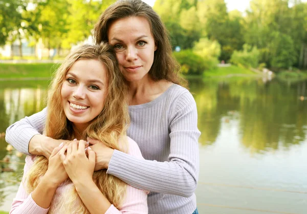 Una Hermosa Joven Con Madre Adulta Abrazándose Fondo Del Lago — Foto de Stock