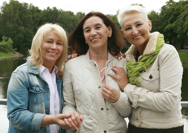 Три Впевнені Літні Жінки Дивляться Камеру Стоячи Разом Парку Недалеко — стокове фото