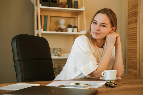 Woman on remote work or online education, using tablet computer, papers and notes, indoors at office or home at daytime. Remote teaching on learning courses for new profession or getting new skills