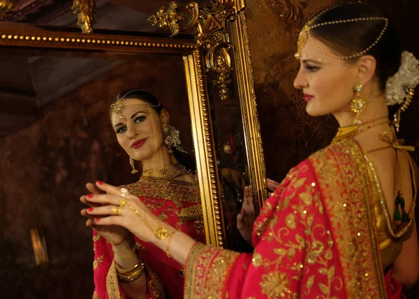 女模特儿印度新娘在萨里 头戴金黄色和茉莉花花环 照镜子 摸他的倒影 回头看 — 图库照片