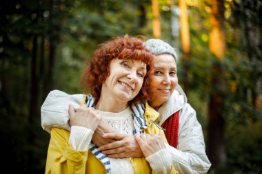 Çok ırklı yaşlı kadınlar ormanda yürüyüş günlerinde eğleniyorlar. Yaşam tarzı ve altın çağ konsepti.