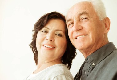 Aile bağları, sevgi ve şefkat kavramı. Güzel, mutlu, Kafkasyalı, emekli karı-kocanın evde kucaklaşmasının portresi. Sıradan stil.