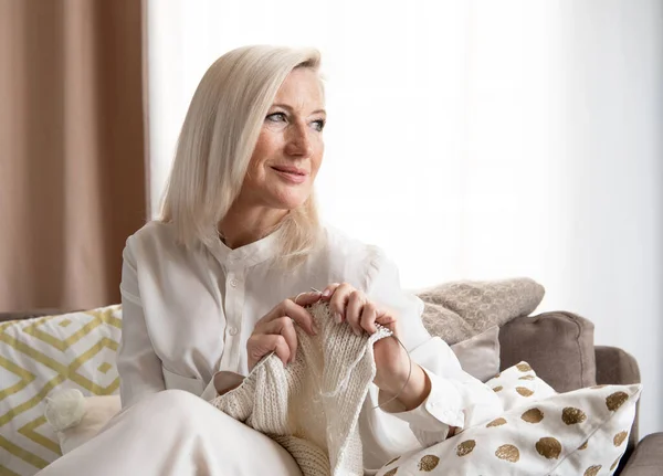 Portret Uśmiechniętej Miłej Dojrzałej Blondynki Siedzącej Kanapie Ręcznie Robionymi Ubraniami — Zdjęcie stockowe