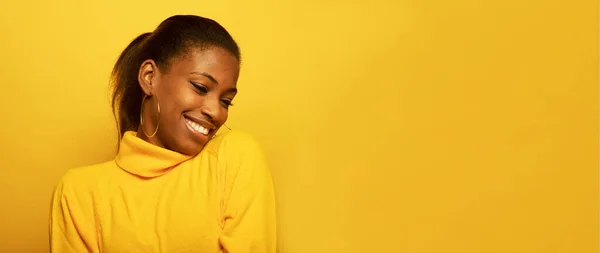 ライフスタイル 人々のコンセプト 黄色の背景の上に大きく笑みを浮かべて 見栄えの良い屈託のないリラックスした若いアフリカ系アメリカ人の若い女性の肖像 — ストック写真