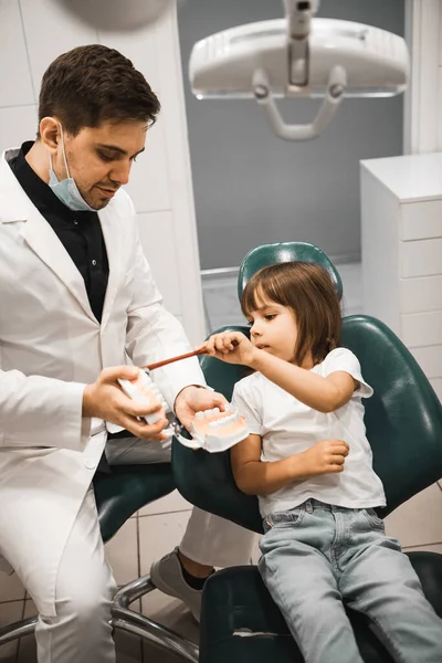 下巴模型上的牙医教一个小女孩刷牙 口腔医学 技术和保健概念 — 图库照片