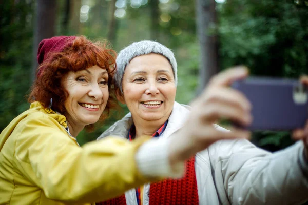 Многорасовые Пожилые Женщины Веселятся Время Похода Лес Делают Селфи Смартфоном — стоковое фото