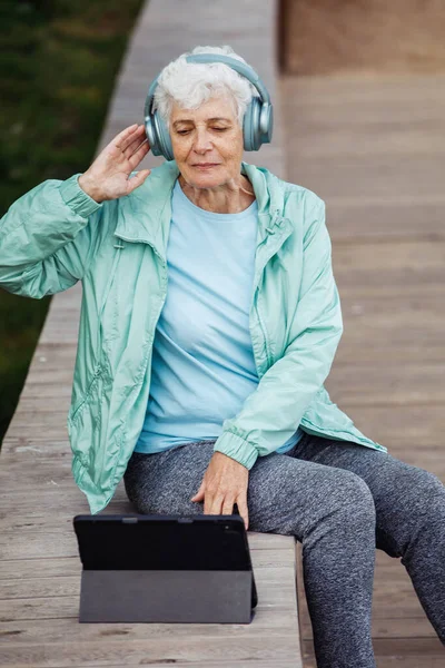 Kulaklıklı Tabletli Büyükanne Müzik Dinliyor Kulaklıklı Tabletli Yaşlı Bir Kadın — Stok fotoğraf