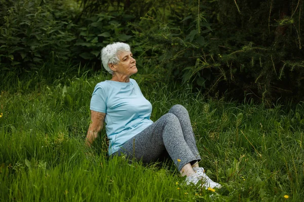 成熟的女人在大自然中放松 老太婆在沉思老太太正在公园里做瑜伽 微笑的老太太在锻炼 关于老年人 年资和健康老龄化的概念 — 图库照片