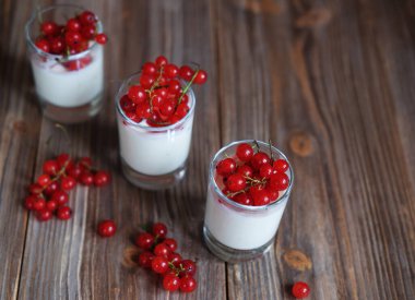 İyi sabahlar. Sağlıklı kahvaltı - beyaz yoğurt, cam kavanozda taze böğürtlen, ahşap arka planda.