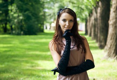 Güzel, zarif genç bayan parkta eğleniyor. Eski tarz. Yaz zamanı..