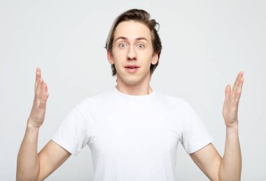 Yaşam tarzı, mutluluk ve insan konsepti: Gri arkaplanda el ele tutuşan genç adam.