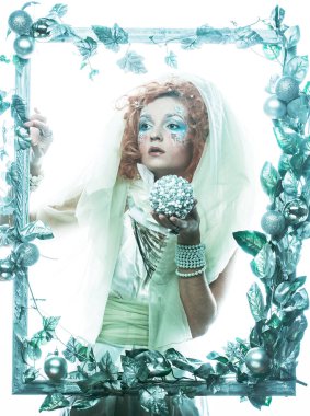 Noel karnavalı için kostüm giymiş güzel bir gigner kadın Noel süslemeleri ve gümüş yapraklar çerçevesinde poz veriyor ve yeni yıl balosu düzenliyor. Yaratıcı makyaj, saç stili.