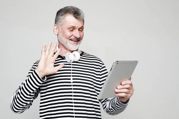 Charming Elderly Man Communicates Friends Using Digital Tablet Headphones Portrait 스톡 이미지