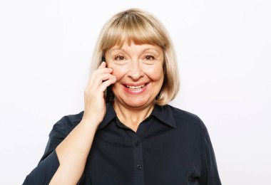 Modern yaşam tarzı, yaşlılar, iletişim ve elektronik aletler. Beyaz taşralı yerine akıllı telefonlu çekici yaşlı kadın.