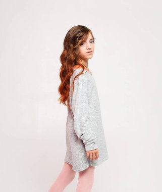 Beyaz arka planda poz veren tatlı kıvırcık kız. Yaşam tarzı ve moda konsepti.