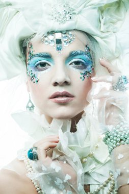 Parti, noel ve halk konsepti: mavi sanatsal makyajlı genç kadın. Kış Portresi. Kar Kraliçesi.