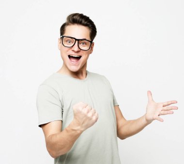 Yaşam tarzı ve duygu konsepti: Mutlu genç yakışıklı adam beyaz arka plan üzerinde hareket ediyor ve ağzını açık tutuyor