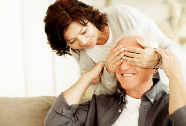 Love lives forever. An elderly couple is in love as in their youth. A woman closes her eyes to her husband, wants to make a surprise.