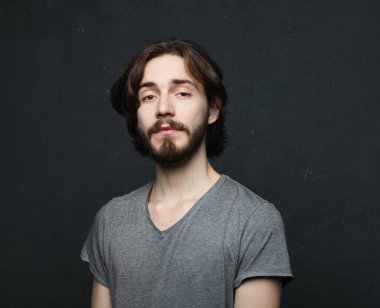 Gri arka planda genç ve yakışıklı bir adam. Stüdyo moda portresi.