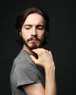 Gri arka planda genç ve yakışıklı bir adam. Stüdyo moda portresi.