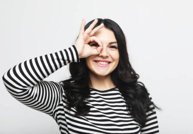 Yaşam tarzı, duygu ve insan konsepti: gülümseyen genç bir kadın mutlu bir şekilde el pençe divan duruyor.