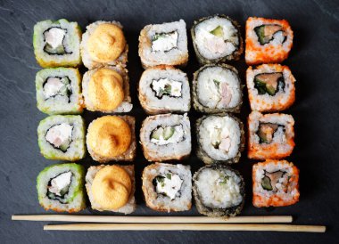 Suşi ve maki seti taş masada. Düz yat, üstten bak, kapat.