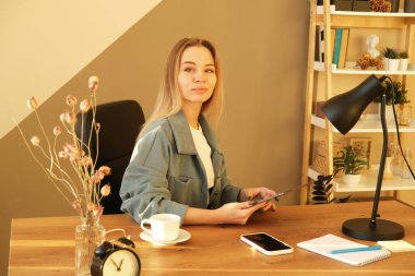 Uzaktan çalışan ya da internetten eğitim alan bir kadın tablet bilgisayar, kağıt ve notlar kullanıyor, gündüz evde ya da ofiste. Yeni meslek öğrenme kursları ya da yeni beceriler edinme üzerine uzaktan eğitim