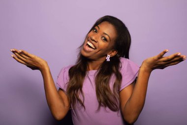 Mutlu afro siyah kadın mutlu, heyecanlı, şaşırmış ya da şaşırmış, gülümseyen ve şaşırmış hissediyor..