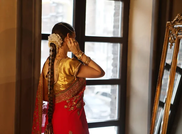 女模印度教新娘在萨里 头戴金黄色和茉莉花花环在靠近镜子的头发 后视镜 — 图库照片