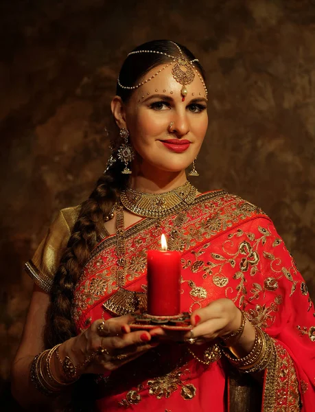 ろうそくを持つ魅力的な若い女性 伝統的なインドの結婚式のサリーとジュエリー — ストック写真