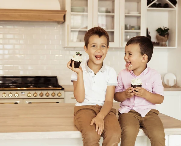 Funny Two Little Brothers Sitting Together Kitchen Table Eating Cupcakes — Stock Photo, Image