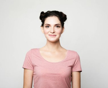 Young cute smiling brunette woman over light grey background