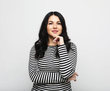 Young cute smiling brunette woman over light grey background
