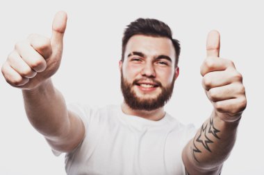 Beyaz arka planda izole edilmiş, iyi bir hareket gösteren neşeli, sakallı genç bir adamın portresi. Yaşam tarzı kavramı.