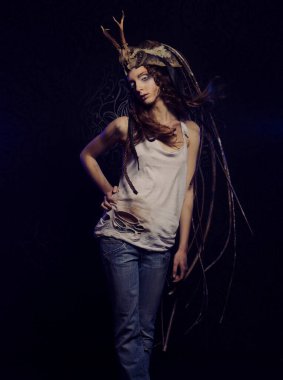 Parlak makyajlı, örgülü saçlı ve kafasında siyah bir arka planda poz veren güzel bir genç kadın. Karnaval partisi, Cadılar Bayramı konsepti.