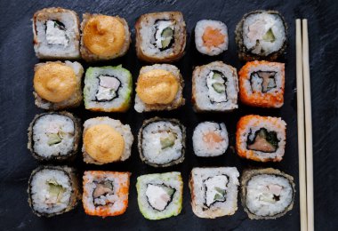 Japon yemeği. Suşi. Philadelphia dürümü taze somon, salatalık, avokado, krem peynir, tobiko havyar. Kapat..