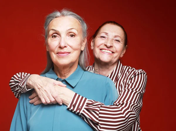Two Elderly Women Friends Hugging Red Background Lifestyle Old People — Stock Fotó