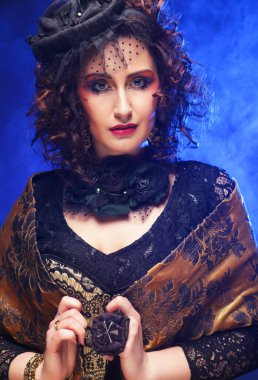 Elegant middle-aged woman in a black hat with a veil and a luxury dress. Vintage style. Beauty and fashion concept.