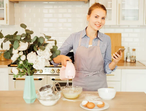 Young Blonde Woman Uses Mixer Whips Cream Cake Stands Modern — Stockfoto