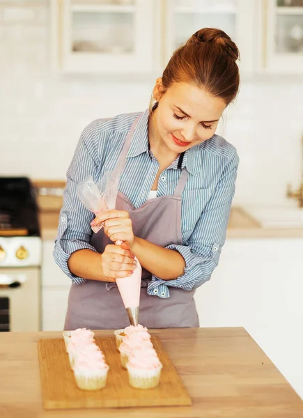 Young Woman Wearing Casual Decorates Muffins Pink Cream Modern Kitchen —  Fotos de Stock