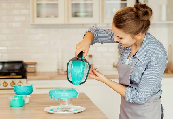 Young Blonde Woman Decorating Cake Blue Icing Modern Kitchen Freelancing — Foto de Stock