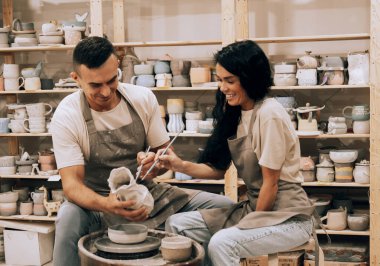 Genç bir çift çömlek atölyesinde çalışıyor. Vazo boyuyorum. Hobi, yaşam tarzı ve ilişkiler kavramı.