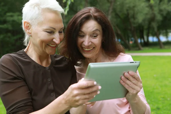 Two Happy Old Women Laugh Merrily Look Screens Tablet Having — стоковое фото