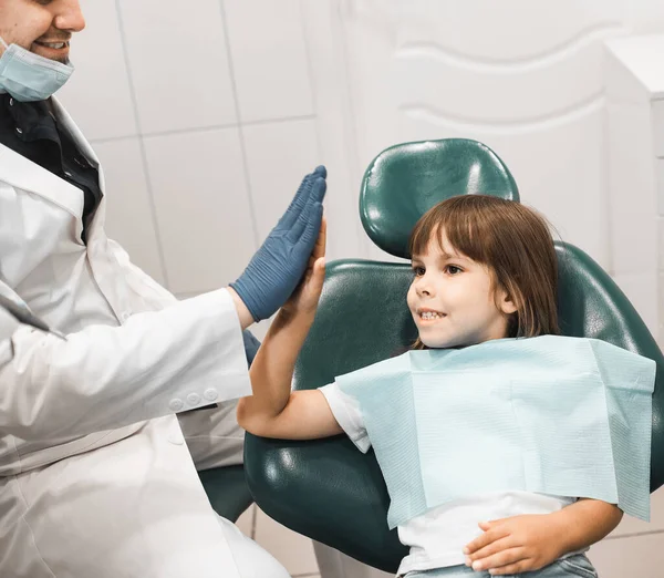 口腔医学 技术和保健概念 在诊所与小女孩一起工作的专业年轻男牙医 — 图库照片